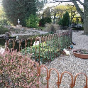 Barres d'acier (rouillées) autour d'un étang de jardin dans le jardin