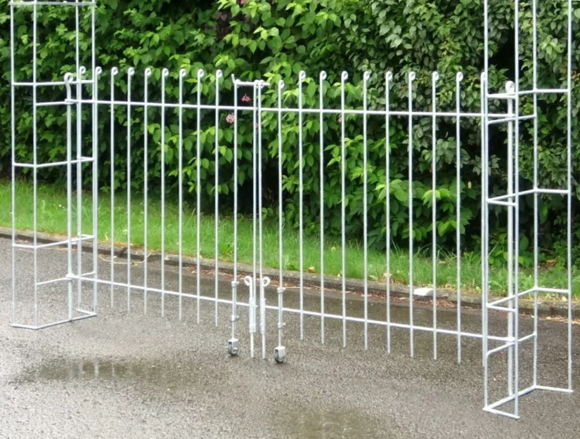 Dubbelvleugelige verzinkte ijzeren poort in een grote rozenboog.