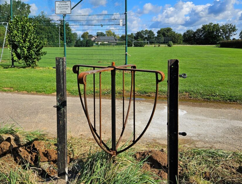 Drehkreuz für Fußgänger und Balljungen zwischen der Wiese und dem Fußballplatz.