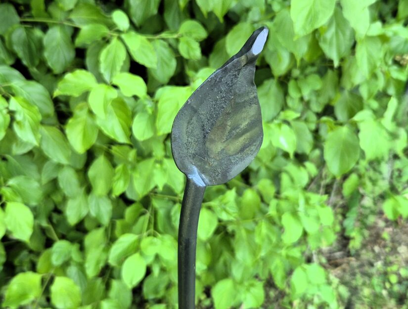 Der Schmiedehammer formt das glühende Stabende zum Blatt, das so seine natürliche Form erhält.