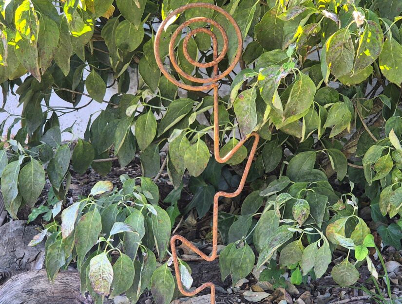 Handwerklich gebogener Stahldraht in dekorativer Blumenform.