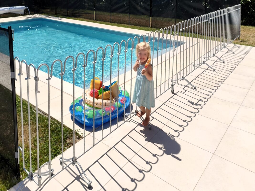 Een mobiel hek voor het zwembad op het terras dient als kinderveiligheid.