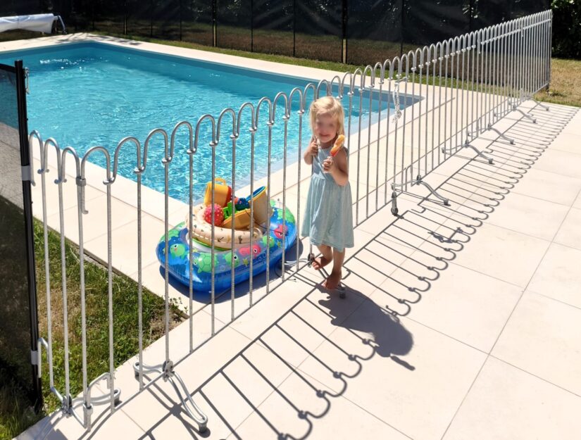 Une barrière mobile devant la piscine sur la terrasse sert à protéger les enfants.