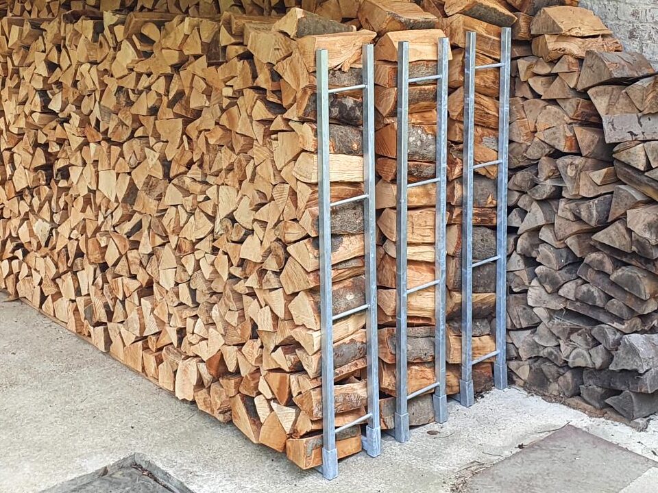 Der Holzstapel kippt nicht mehr um. Das Kaminholz wird gegen die Stütze gestapelt aus Stahl
