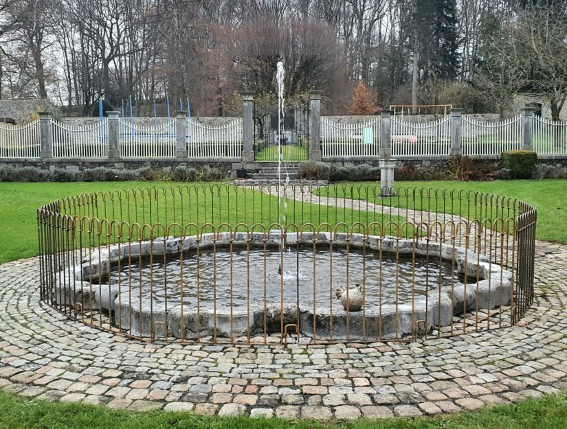 Brunnen Umzäunung in einem Park als Kindersicherung mit dem poolfix-Zaun ohne Füße in roh.