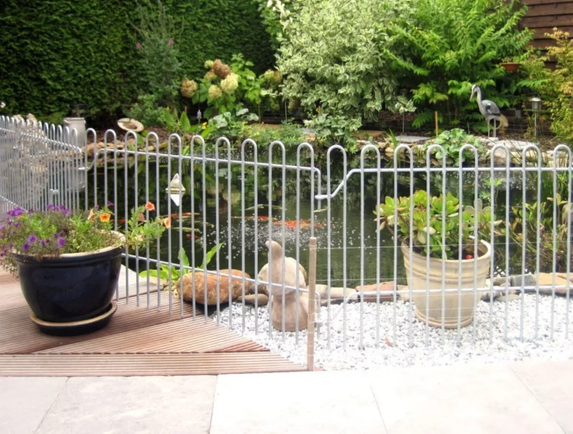 IJzeren hek als bescherming tegen reigers voor een visvijver.