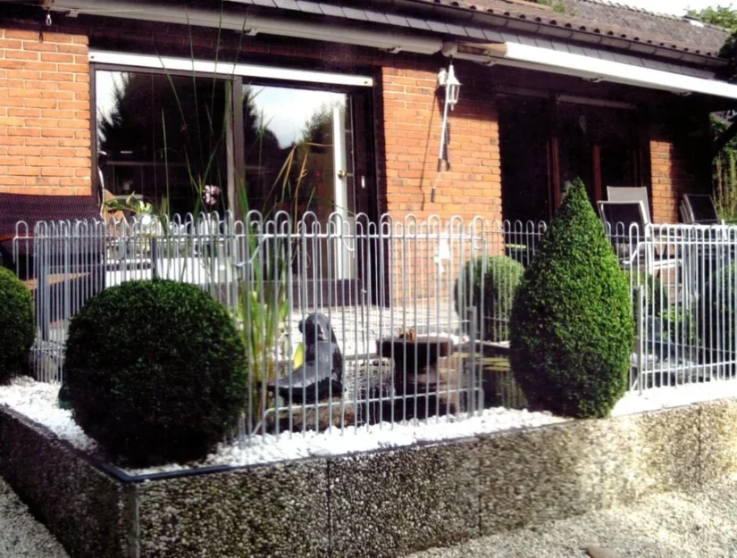 Omheining van gegalvaniseerd ijzer rond een waterbassin op het terras.