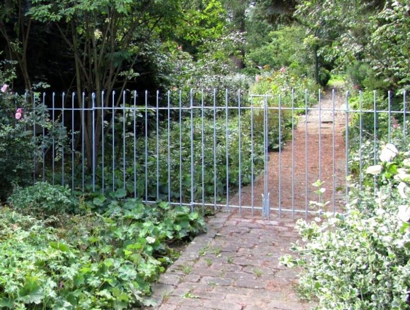 Porte légère à double battant (2 battants de 66 cm de large chacun) donnant sur un chemin de jardin. 