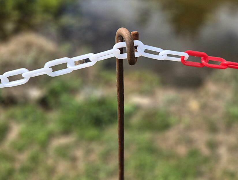 Gerosteter Kettenhalter mit einer rot-weißen Kunststoffkette.