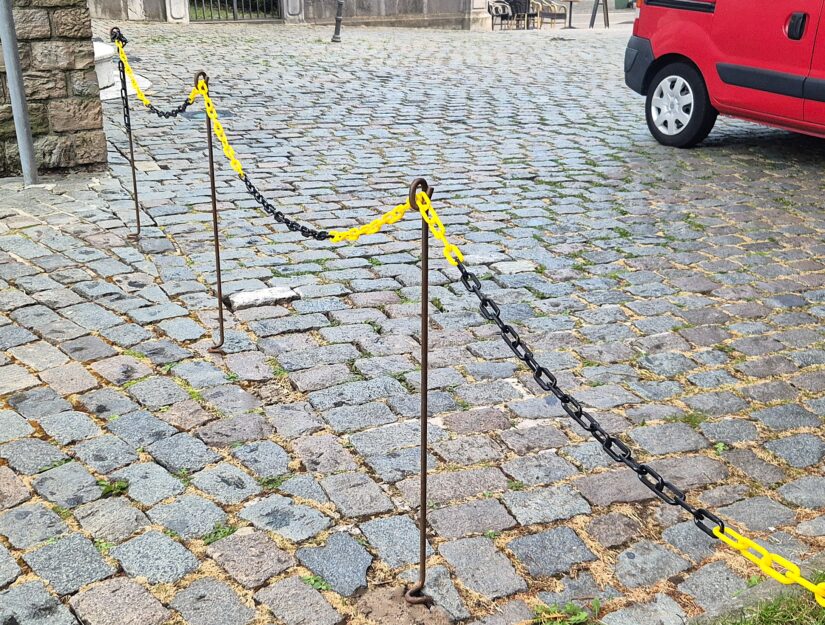 Der Durchgang ist mit einer Kunststoffkette für Autos abgesperrt.