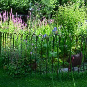 Gartenteich mit einem Zaun aus Stahl, der um den Teich in den Boden gesteckt ist