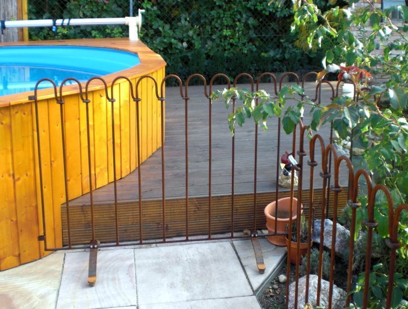 La clôture de la piscine non traitée - l’aspect rouillé est également du plus bel effet.