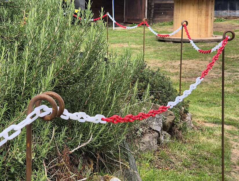 Verroeste afsluitpalen met een rood-witte kunststofketting.