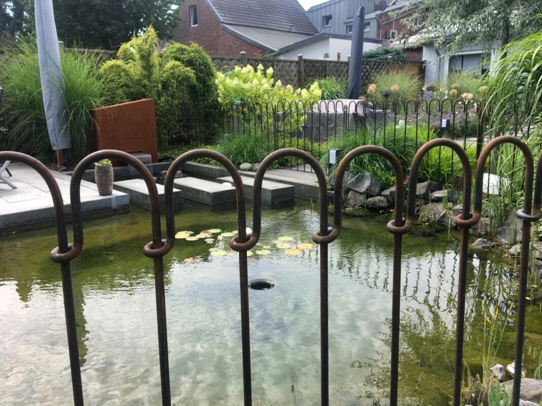 Teichzaun aus rostigem Eisen gebogene Bögen