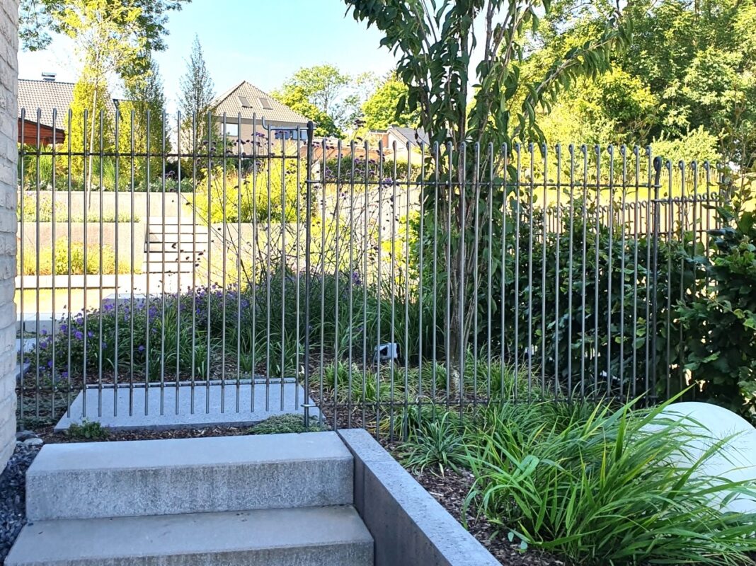 Derrière l'escalier, la porte permet d'accéder au jardin clôturé.