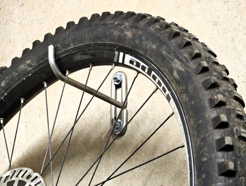 Ein 25 kg schweres E-Bike hängt mit dem Vorderrad im Haken.