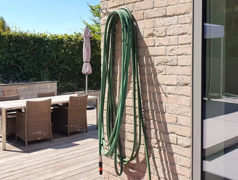 Het is ook mogelijk om een tuinslang aan de houder te hangen.