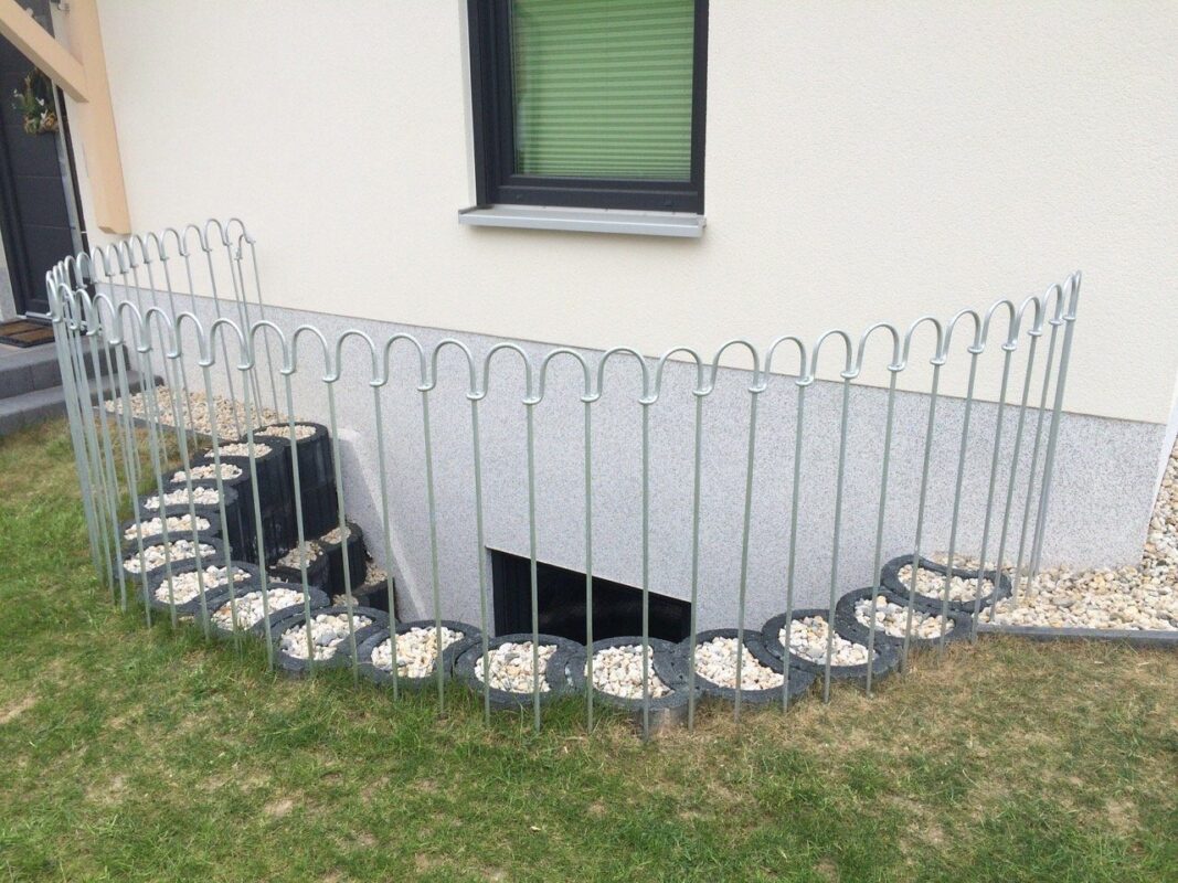 Metall Zaun vor einem Lichtschacht zum Kellerfenster