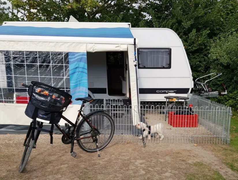 Hek als hondenren voor een caravan op de camping.